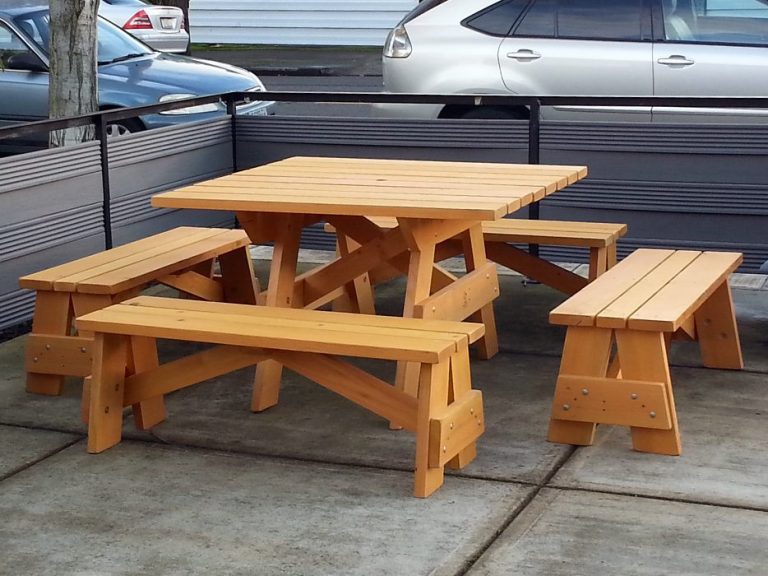Commercial quality Eco Outdoor Square Detached Bench Picnic Table with four benches slanted left at a restaurant bar.