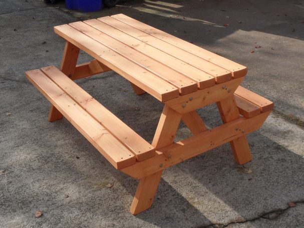 Commercial quality Eco-friendly Outdoor Kids Attached Bench Picnic Table slanted to the left on a sidewalk.