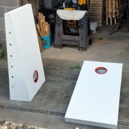 Front of a set of two sturdy high quality solid box design Cornhole Boards one standing up and one lying flat.