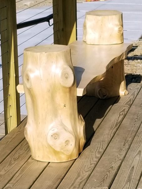 Handcrafted Pine Log Live Edge Slab Bench on the patio at High Grain Brewery from the side.