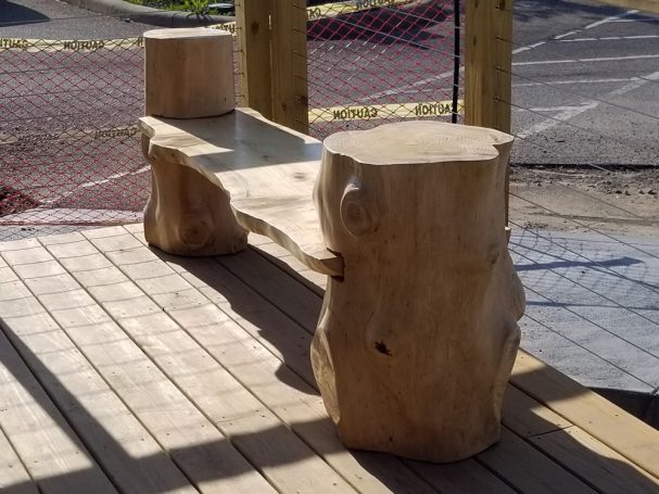 Handcrafted Pine Log Live Edge Slab Bench on the patio at High Grain Brewery slanted to the left.