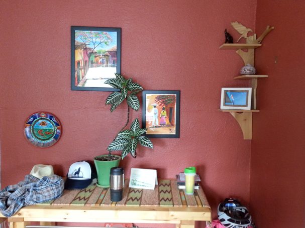 Close up of a Handcrafted Poplar Bird and Tree Corner Shelf hanging in the corner of a red room.