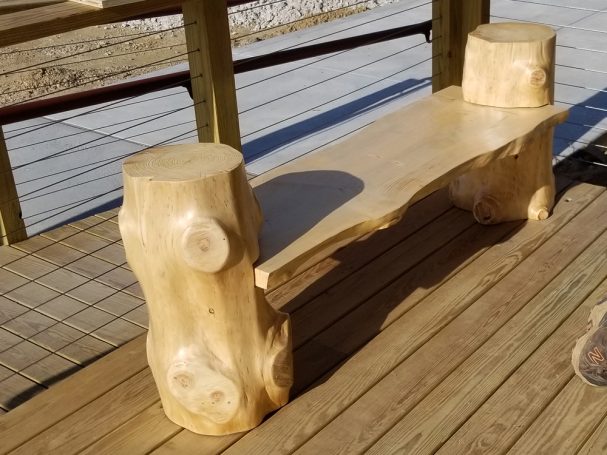 Handcrafted Pine Log Live Edge Slab Bench on the patio at High Grain Brewery slanted to the right.